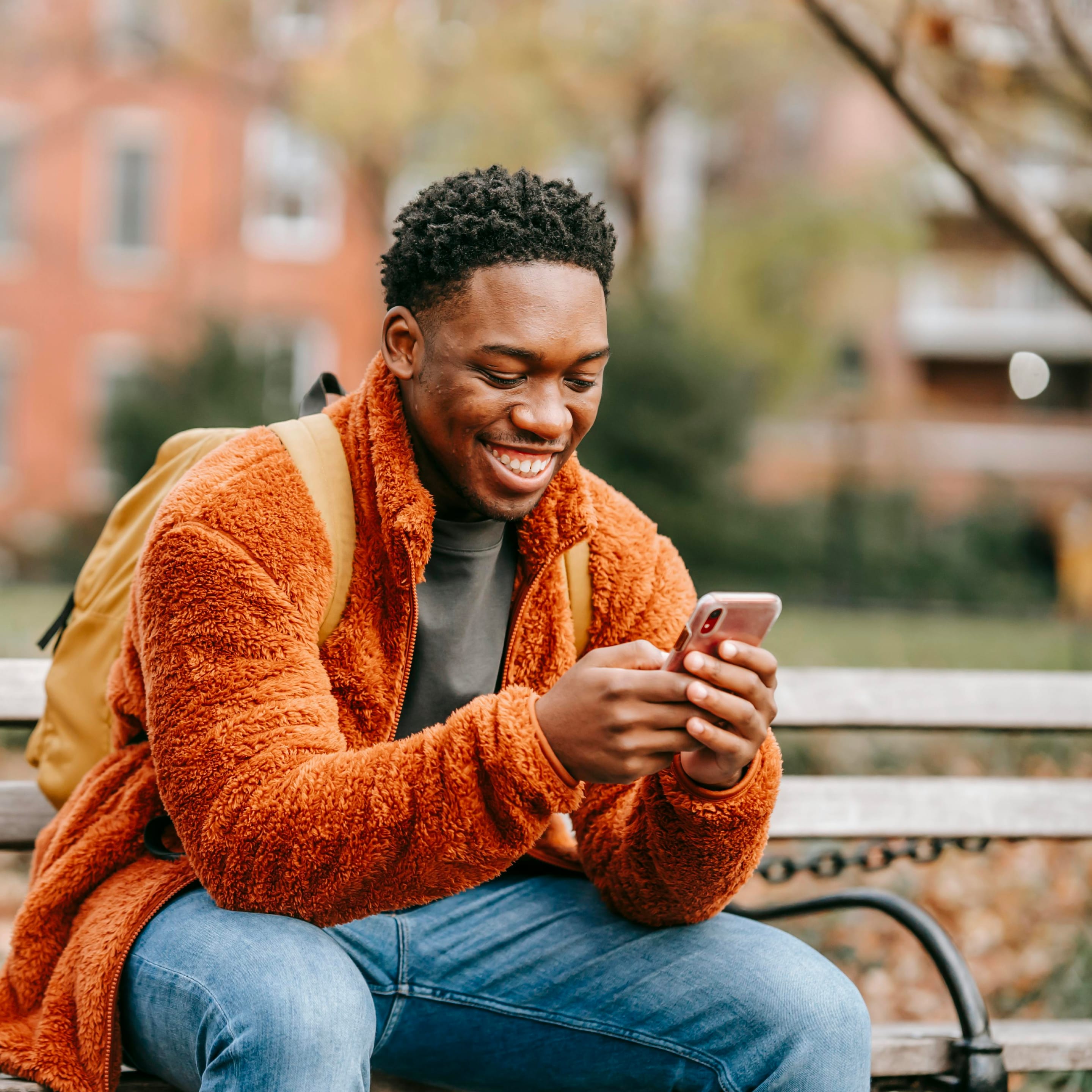 Homme souriant en regardant son téléphone
